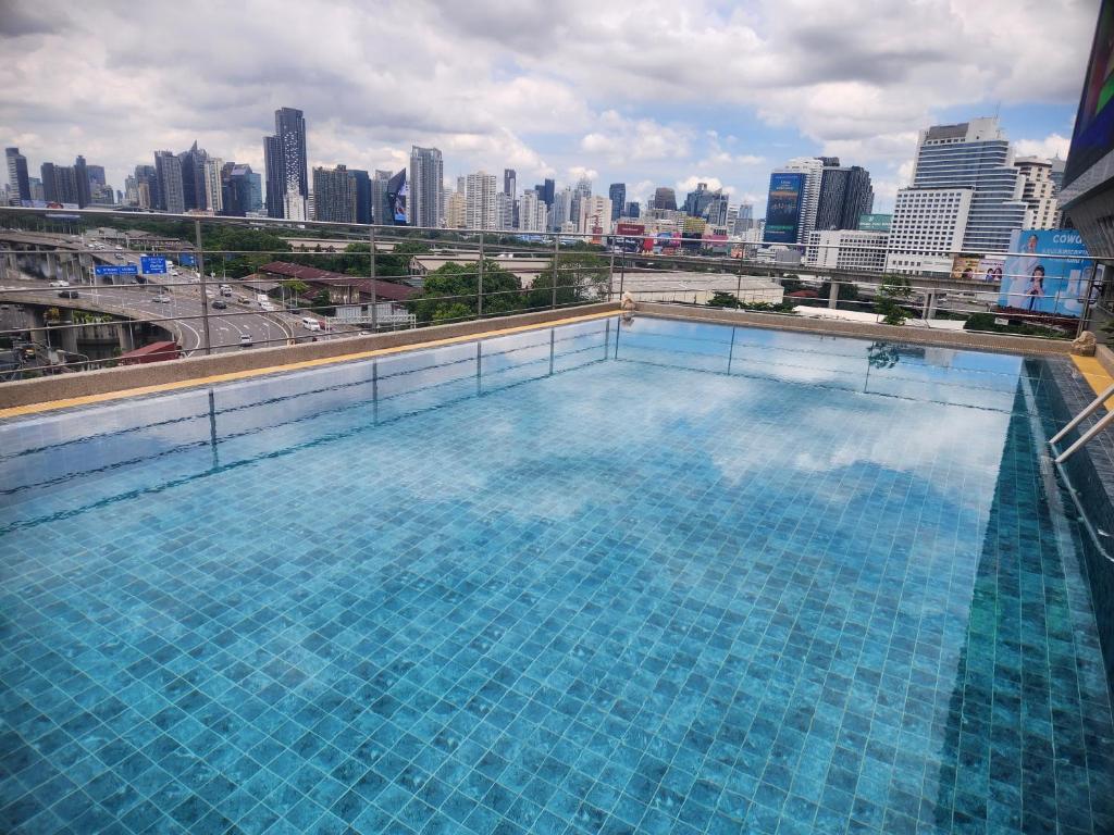 een groot zwembad met een skyline van de stad op de achtergrond bij Interchange Tower Serviced Apartment - SHA Extra Plus in Bangkok