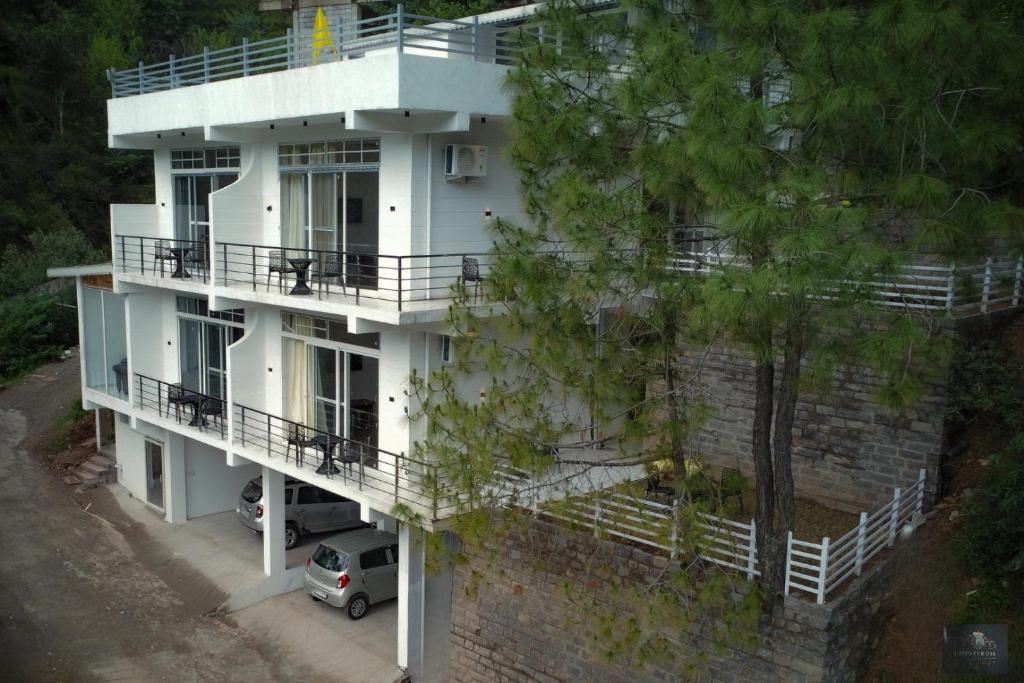 an aerial view of a white building with a parking lot at Chester Oak Kasauli - Premium rooms and Exclusive Villa in Kasauli