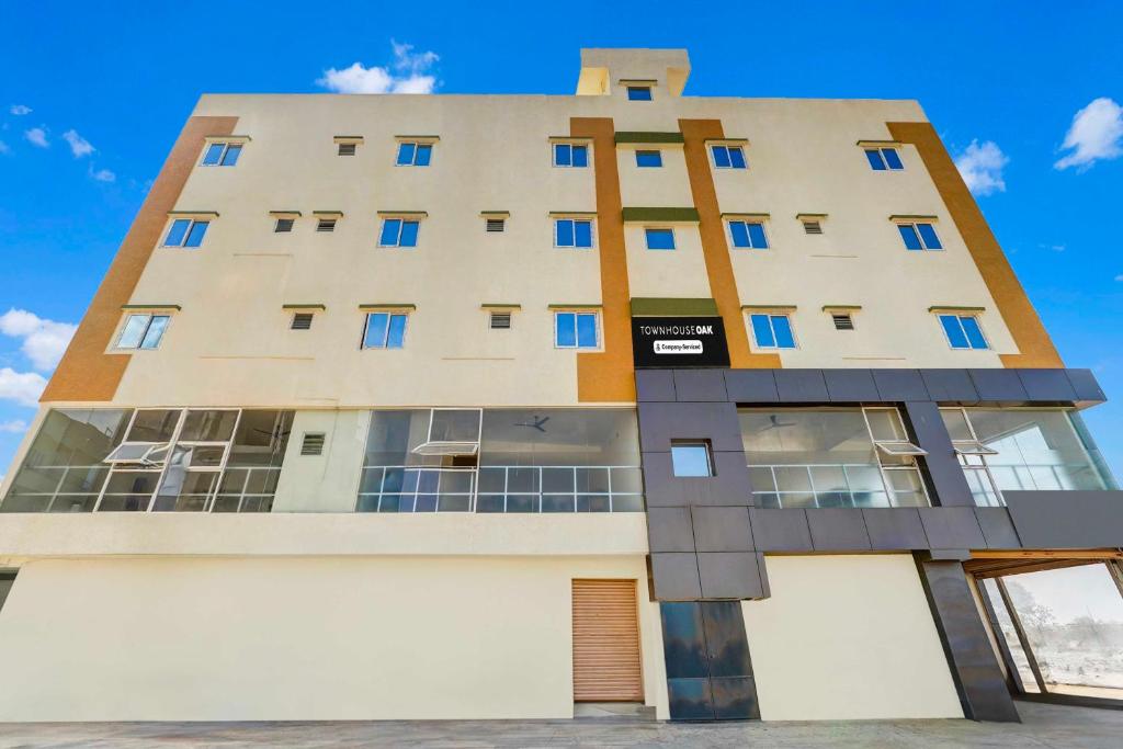 a building with blue windows on the side of it at Townhouse Oak Hennur Prakruthi Layout Bangalore in Bengaluru