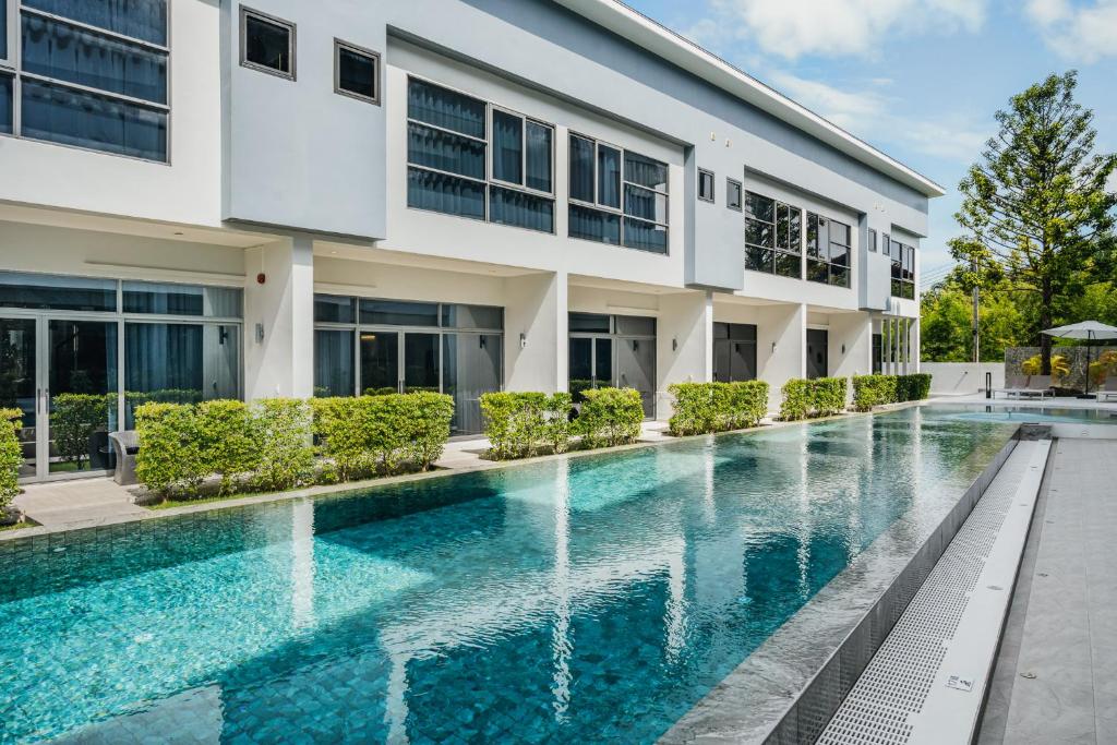 an exterior view of a building with a swimming pool at RYANNA Samui in Choeng Mon Beach