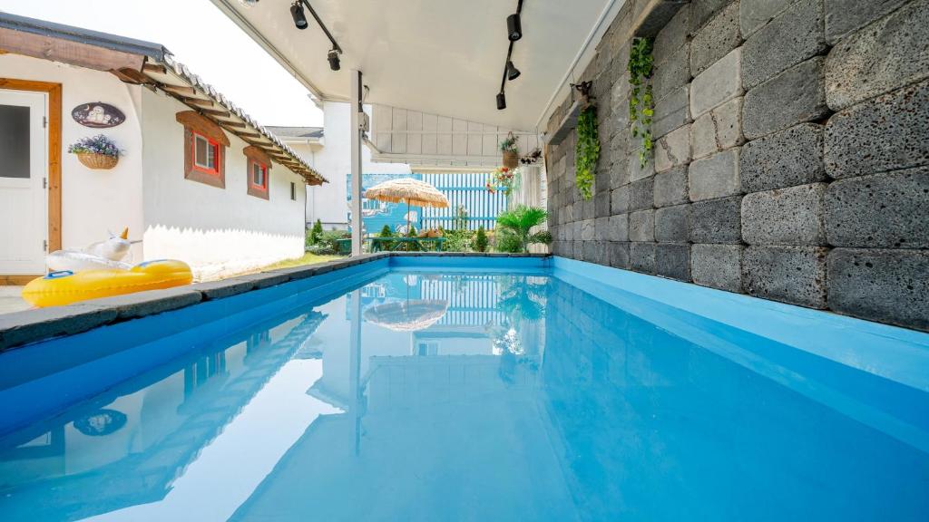 ein Pool mit blauem Wasser in einem Haus in der Unterkunft Gangneung ggabinejip hanok pension in Gangneung