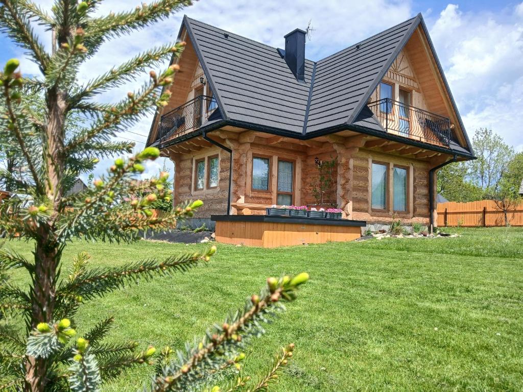 una casa de madera con techo negro en un patio en Tatra West Farm, en Dzianisz
