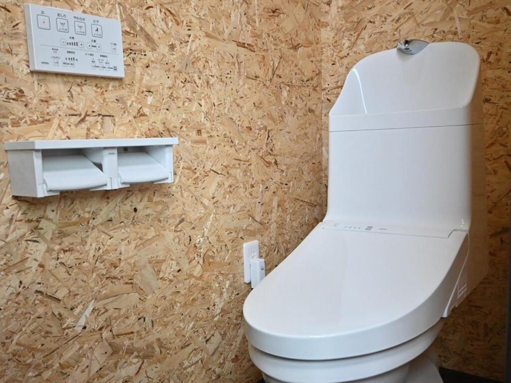 萩市にあるｹﾞｽﾄﾊｳｽ ﾊﾞｲｸﾔﾉﾆｶｲの白いトイレと壁が備わるバスルーム