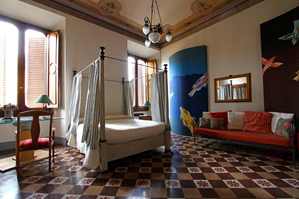 ein Wohnzimmer mit einem Bett und einem Sofa in der Unterkunft B&B Canto Alla Porta Vecchia in Pistoia