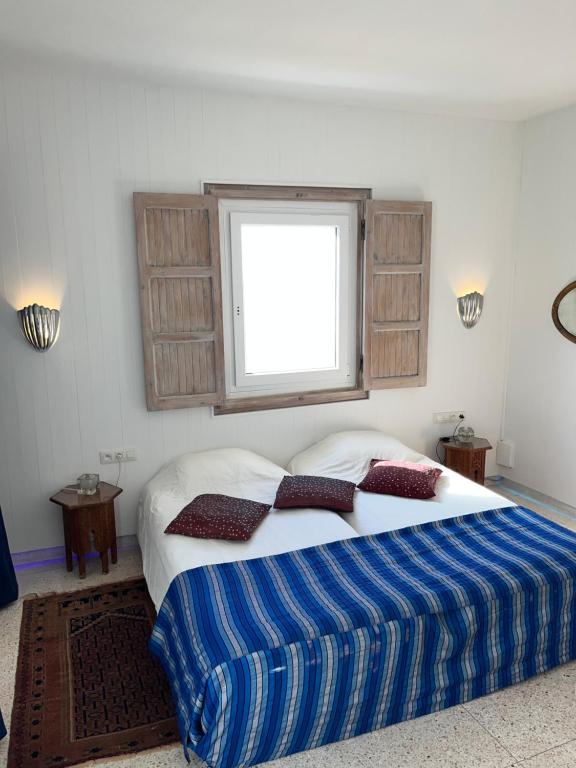 a bedroom with a bed with two pillows and a window at logis la marine in Sidi Ifni