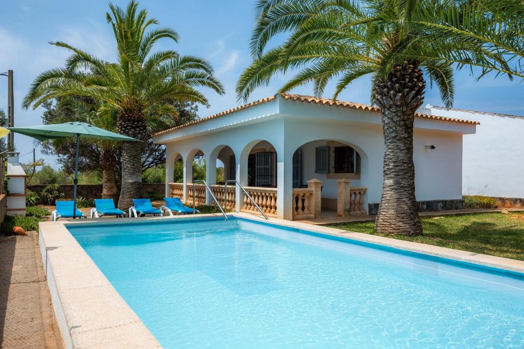 a villa with a swimming pool and palm trees at Sa Torre Nova Ref 50 in Sant Llorenç des Cardassar