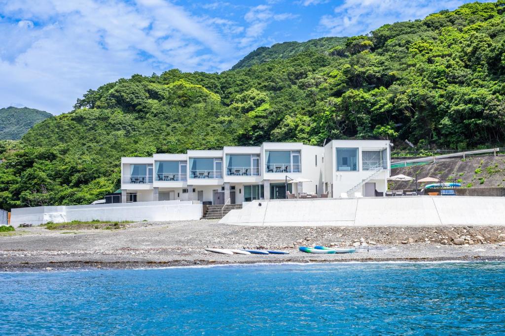 a house on the beach next to the water at 熊野古道ビーチテラス串本 in Wabuka