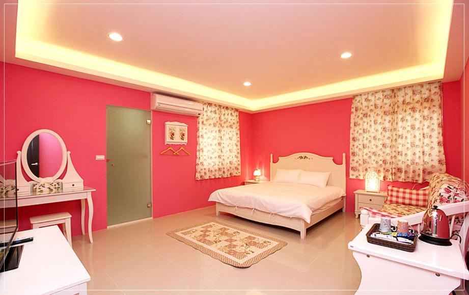 a bedroom with a white bed and red walls at Color Sea B&amp;B in Dawu