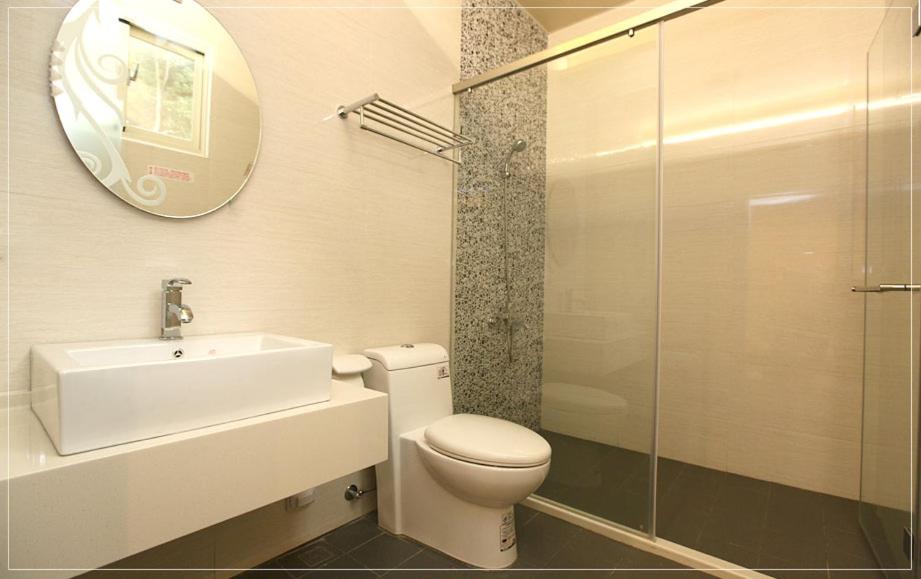 a bathroom with a toilet and a sink and a mirror at Color Sea B&amp;B in Dawu