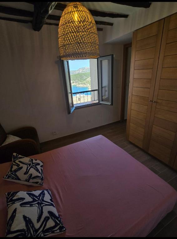 une chambre avec un grand lit et une fenêtre dans l'établissement Bonifacio Appartement charme vieille ville, à Bonifacio