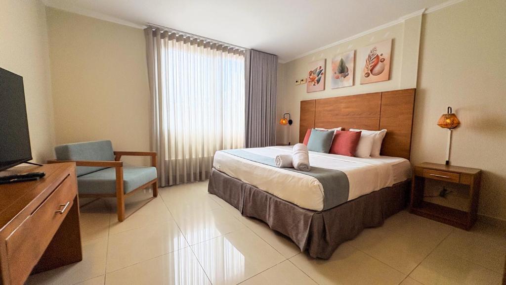 una habitación de hotel con una cama y un televisor en Majestic City Suites &amp; Beach Hotel, en Willemstad
