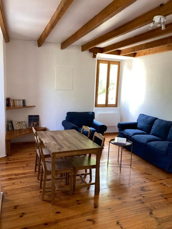un salon avec une table et un canapé bleu dans l'établissement Confortable logement au coeur des montagnes, au Lauzet-Ubaye