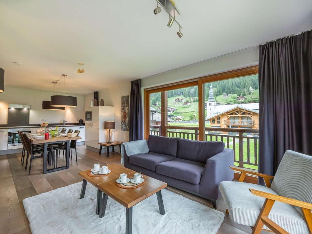 un salon avec un canapé bleu et une cuisine dans l'établissement Apt Oasis B107 - La Chapelle D'Abondance - BO Immobilier, à La Chapelle-dʼAbondance