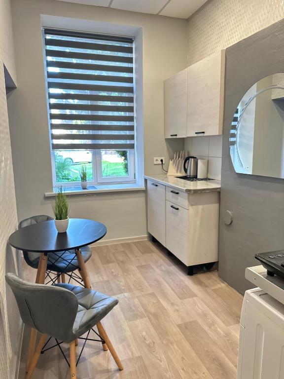 a kitchen with a table and chairs and a window at KunK in Ventspils