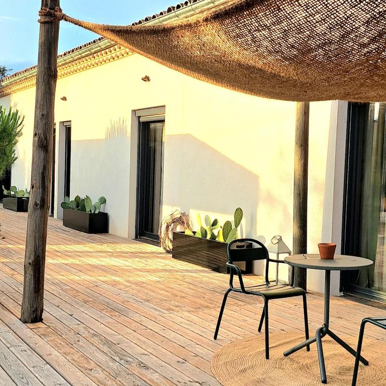 d'une terrasse avec un hamac, une table et des chaises. dans l'établissement La maison du bonheur, à Saint-Siffret