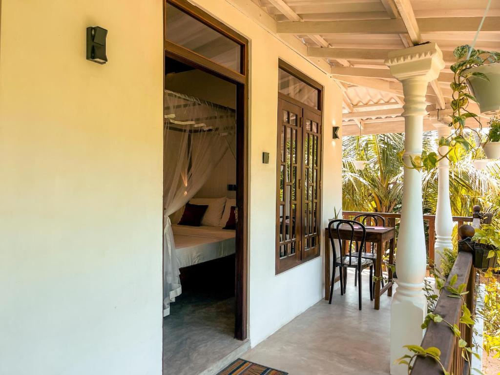 una porta aperta su una camera da letto con tavolo e sedie di Coconut Beach House a Galle