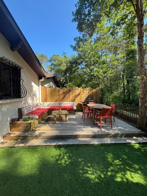 une arrière-cour avec une terrasse dotée d'une table et de chaises dans l'établissement Hossegor - Lac - Forêt - Couple - Piscine, à Soorts-Hossegor