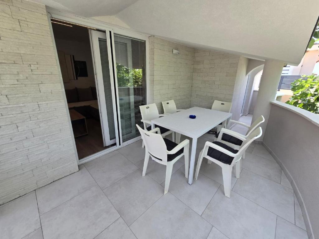 un tavolo bianco e sedie su un balcone di Apartments Ivankovic a Nin
