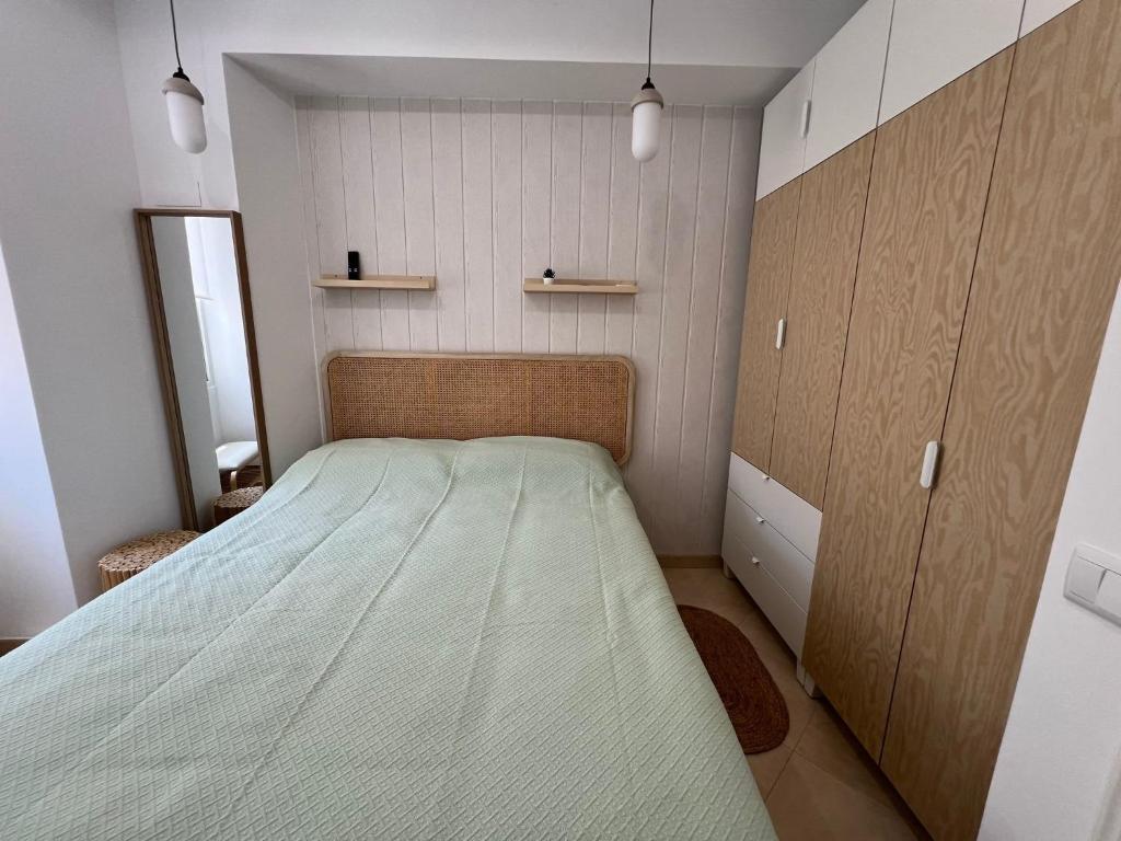 a small bedroom with a bed and a cabinet at Blue Bay Beach Apartment - Maria in Sesimbra