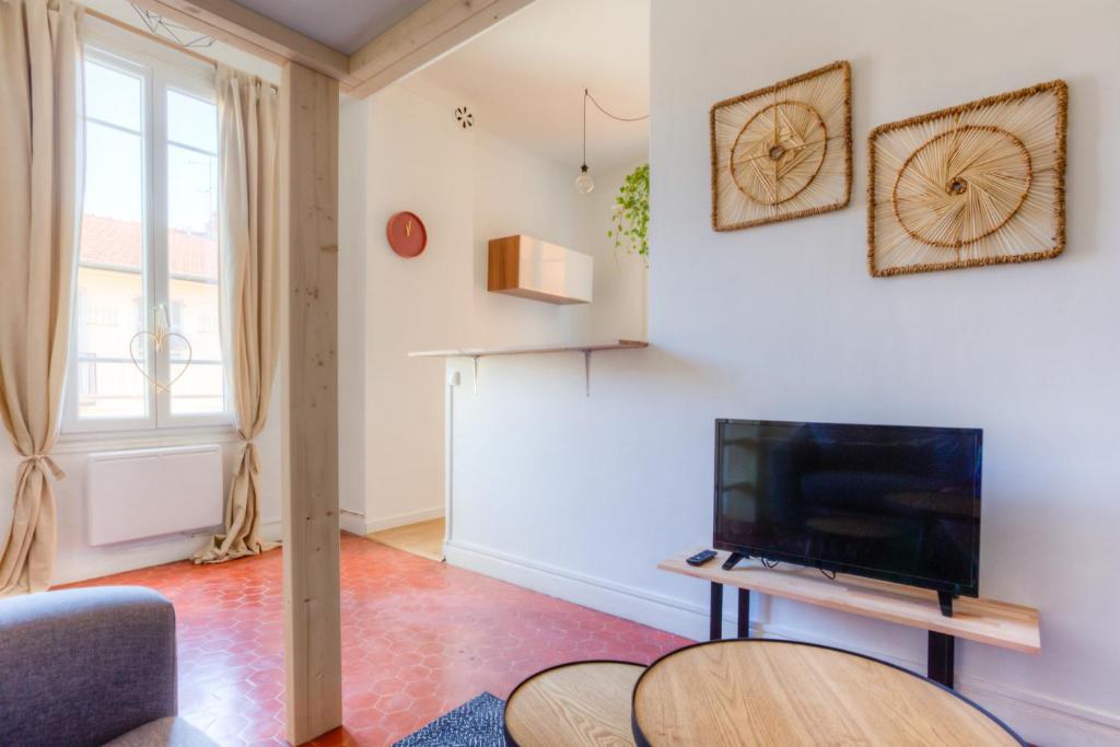 un salon avec une télévision et une table dans l'établissement Studio Francois Guisol, à Nice