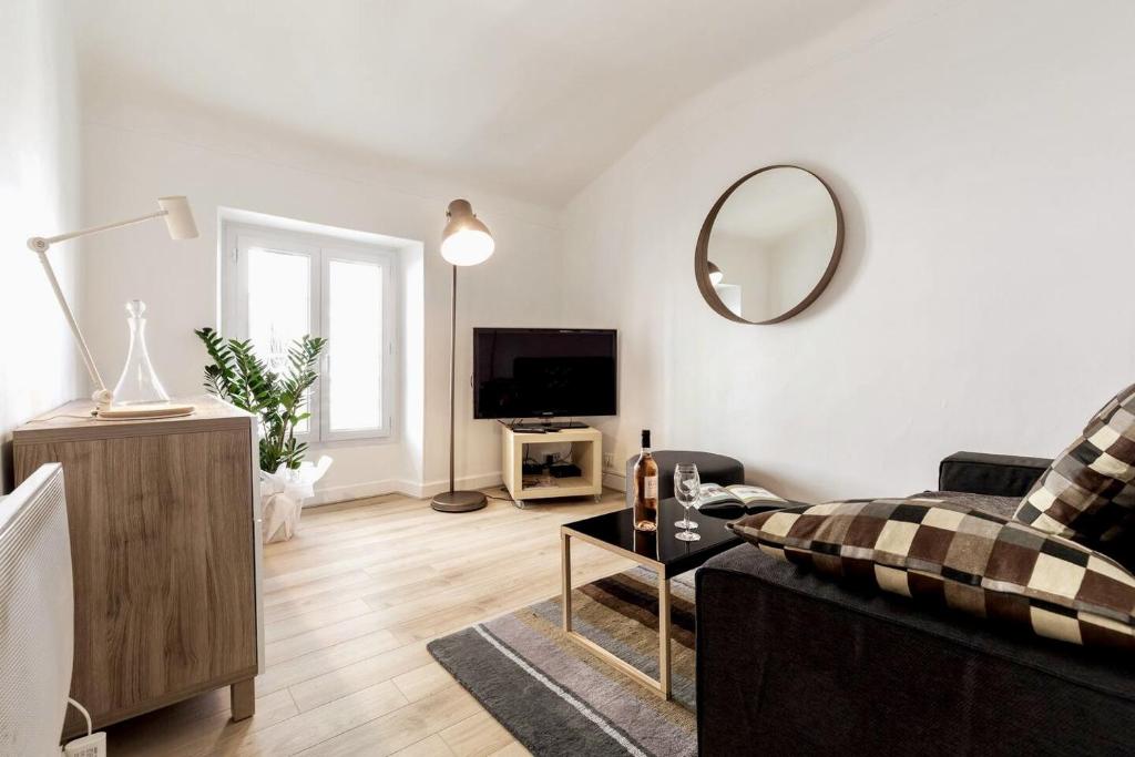 un salon avec un canapé et un miroir dans l'établissement T2 Bonaparte Place du Pin Port Nice, à Nice