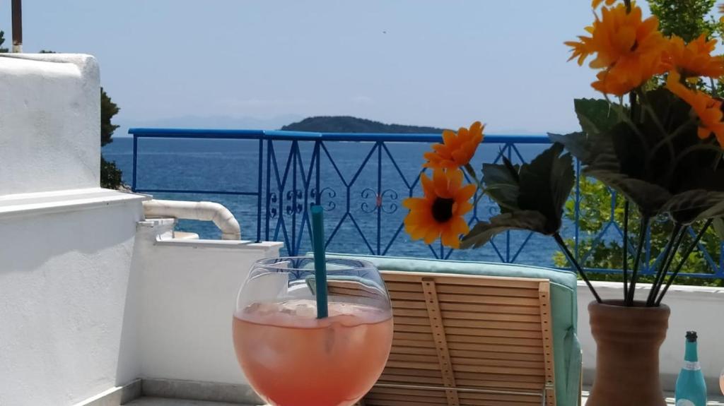a drink sitting on a balcony with a view of the ocean at Emerald Blue in Skiathos