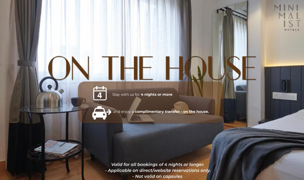 un poster per una camera d'albergo con un divano e un letto di Minimalist One Hauz Khas Village a Nuova Delhi