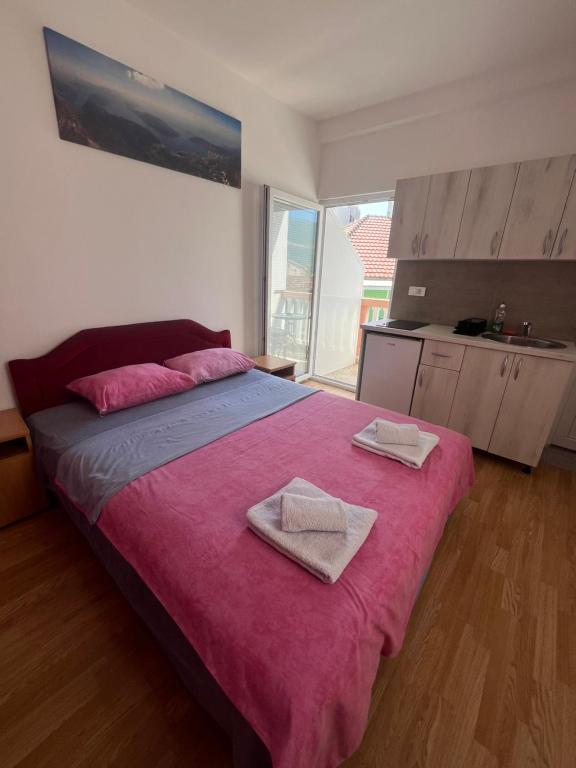 um quarto com uma cama grande com duas toalhas sobre ela em Vasiljević apartmani em Igalo