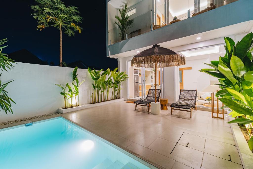 una piscina in una casa con sedie e piante di Villa Balinay - 2 Bedrooms Walkable to Canggu Beaches a Canggu