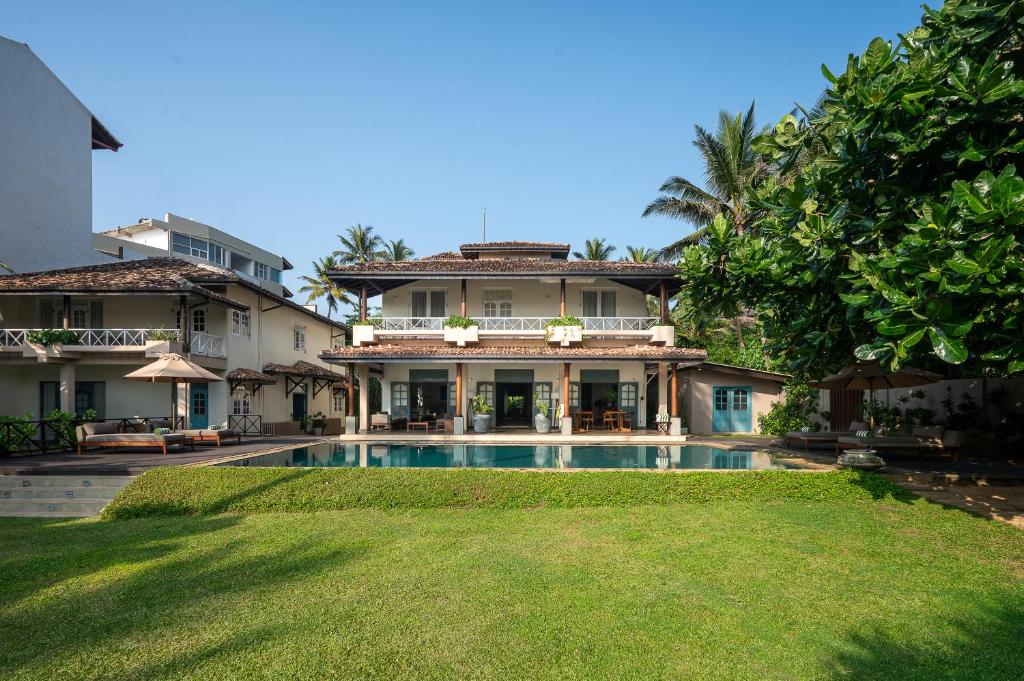 una casa con piscina frente a un patio en On The Rocks, en Unawatuna