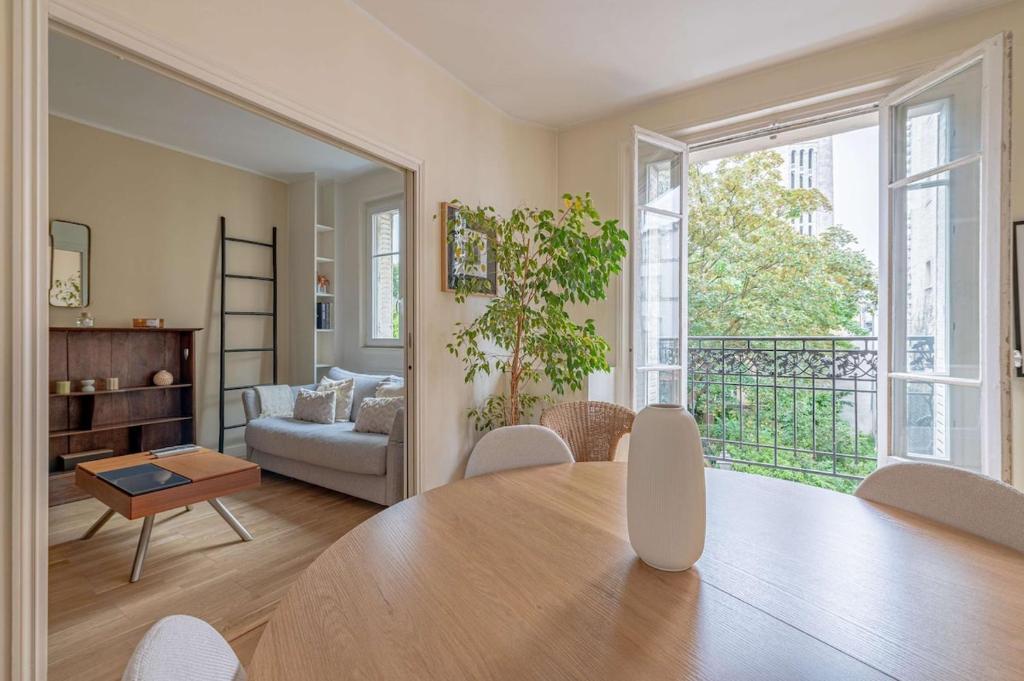 d'une salle à manger avec une table et d'un salon avec un canapé. dans l'établissement Montmartre Heaven 1 Bed 4 PPL, à Paris