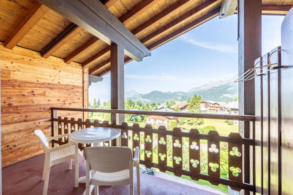 a room with a balcony with a table and chairs at Studio 18 - Le Chamois in Crest-Voland