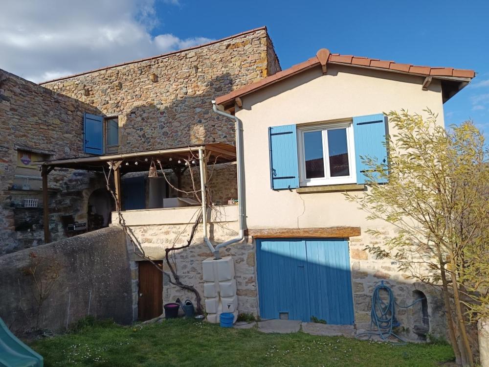 une maison avec une porte bleue sur son côté dans l'établissement Gite typique 6 personnes, à Saint-Yvoine
