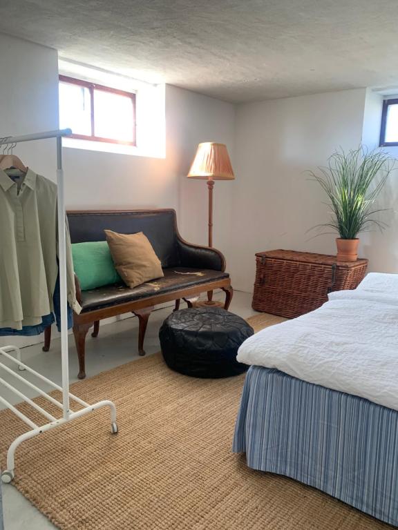 a living room with a bed and a couch at Village house & garden for summer hangout near Sankt Olof in Onslunda