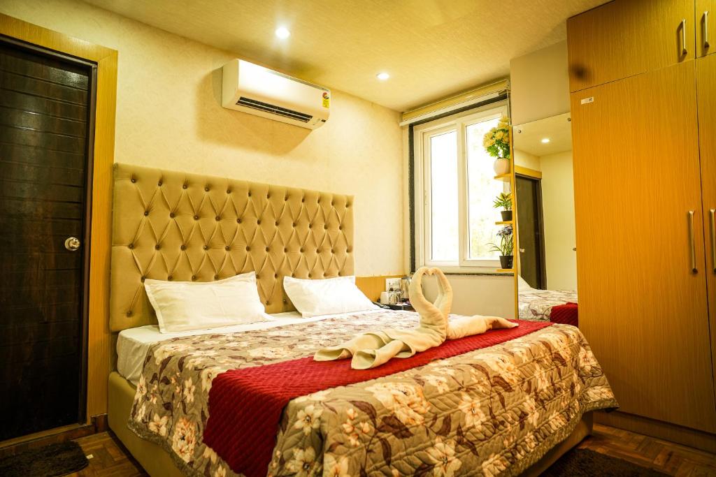 a bedroom with a bed with a stuffed animal on it at Rose Manor suites in Dehradun