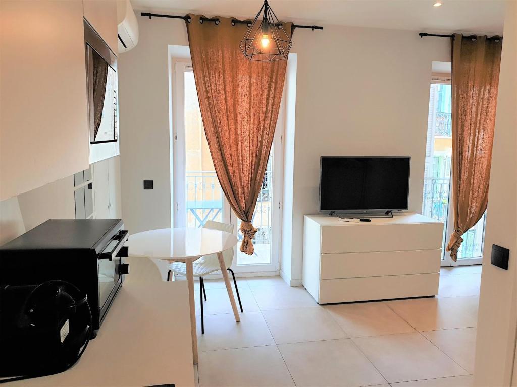un salon avec une télévision et une table blanche dans l'établissement Studio centre mer 306, à Nice