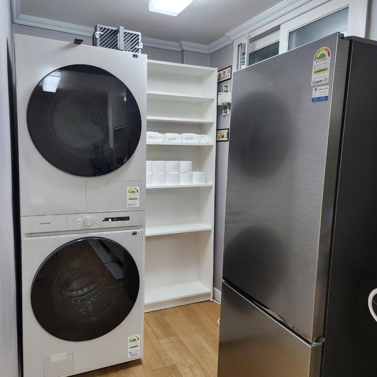 a washer and dryer next to a refrigerator at Dongdaemun Myeongdong 6BED in Seoul