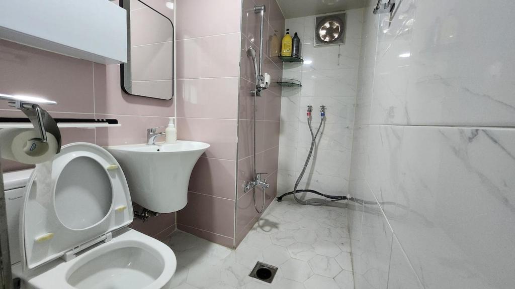 a bathroom with a toilet and a sink and a shower at Dongdaemun Myeongdong 6BED in Seoul
