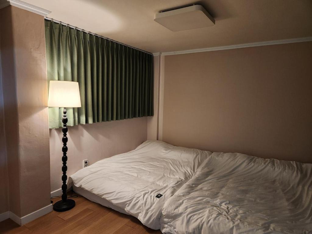 a bed in a room with a lamp and a window at Dongdaemun Myeongdong 6BED in Seoul
