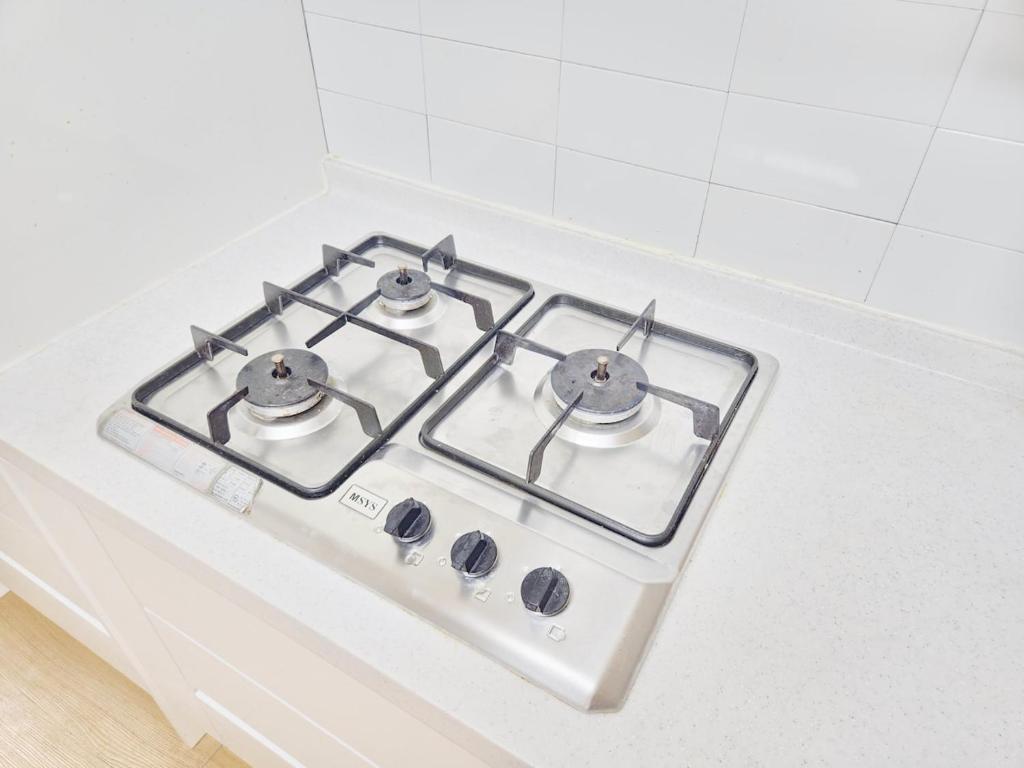 a white stove top with four burners on a counter at Dongdaemun Myeongdong 6BED in Seoul