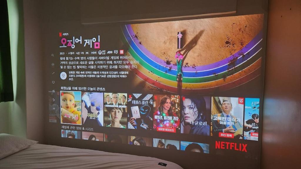 a wall with a tv with a poster on it at Dongdaemun Myeongdong 6BED in Seoul