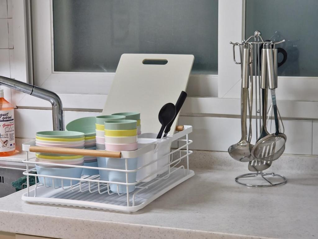a dish drying rack with dishes and utensils on a kitchen counter at Dongdaemun Myeongdong 6BED in Seoul