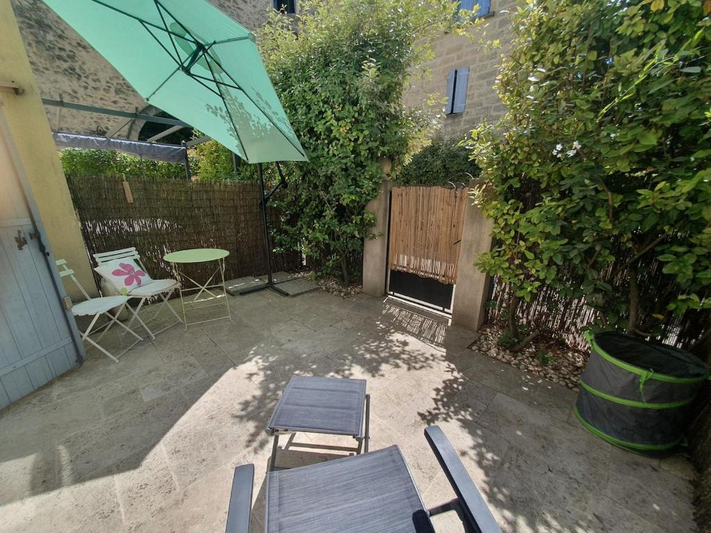 un patio avec une table, des chaises et un parasol dans l'établissement A nice break, à Uzès