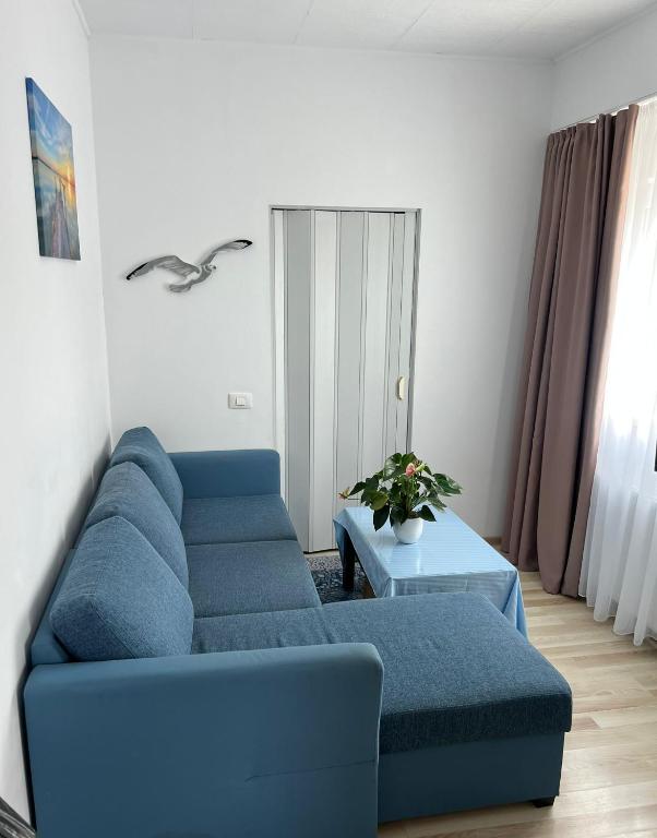 a living room with a blue couch and a table at Studio 1 & Studio 2 Aqua in Eforie Nord