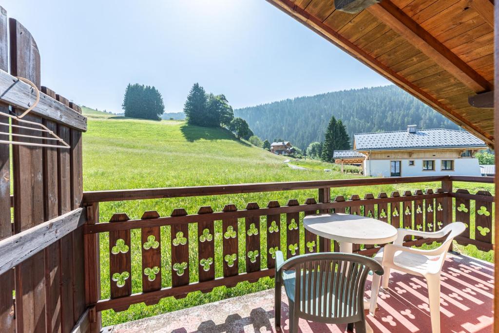 un patio avec une table et des chaises sur un balcon dans l'établissement Studio 16 - Le Lagopede, à Cohennoz