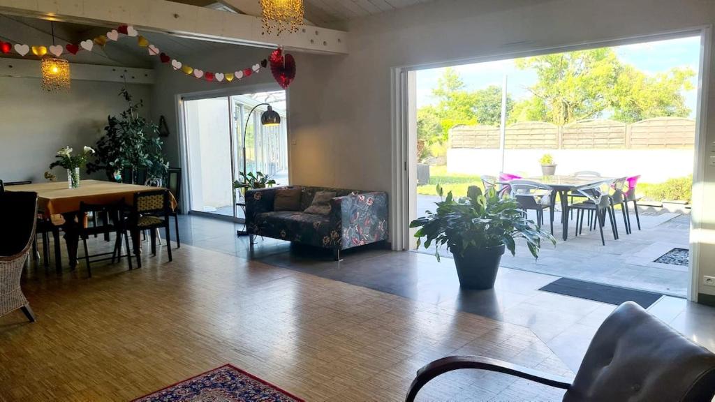 a living room with a couch and a table and chairs at Villa avec piscine et magnifique jardin ! Villa with swimming pool and magnificent garden! in Aigrefeuille-sur-Maine