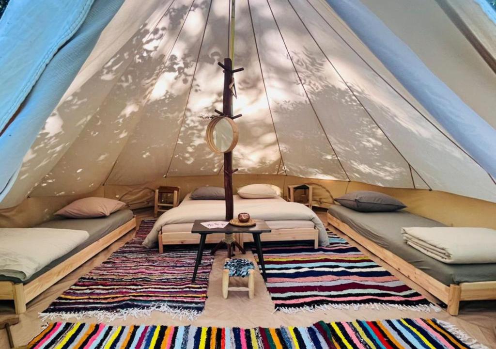 une chambre avec deux lits dans une tente dans l'établissement Kârma Hôtel, à Saint-Germain-Laval