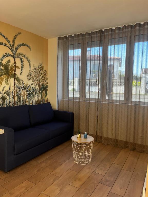 un salon avec un canapé noir et une table dans l'établissement Studio porte royale, à La Rochelle