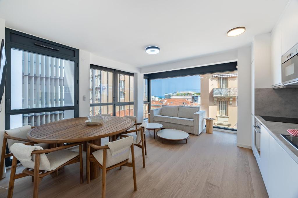 une cuisine et un salon avec une table et des chaises dans l'établissement Charming Apartment III 2BR Beausoleil Monaco, à Beausoleil