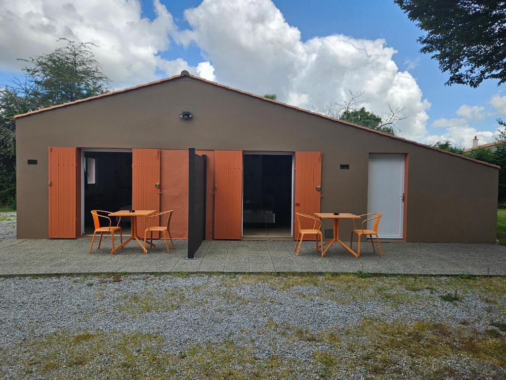 un bâtiment avec des tables et des chaises devant lui dans l'établissement Laurier ET Menthe, à Challans